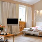 Suite Bayern - Helles einladendes Schlafzimmer mit Holzverkleidungen und hellen Vorhängen