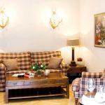 Suite Senator Rösner - Wohnhzimmer - Beige grau gestreifte Möbel mit antikem Holztisch